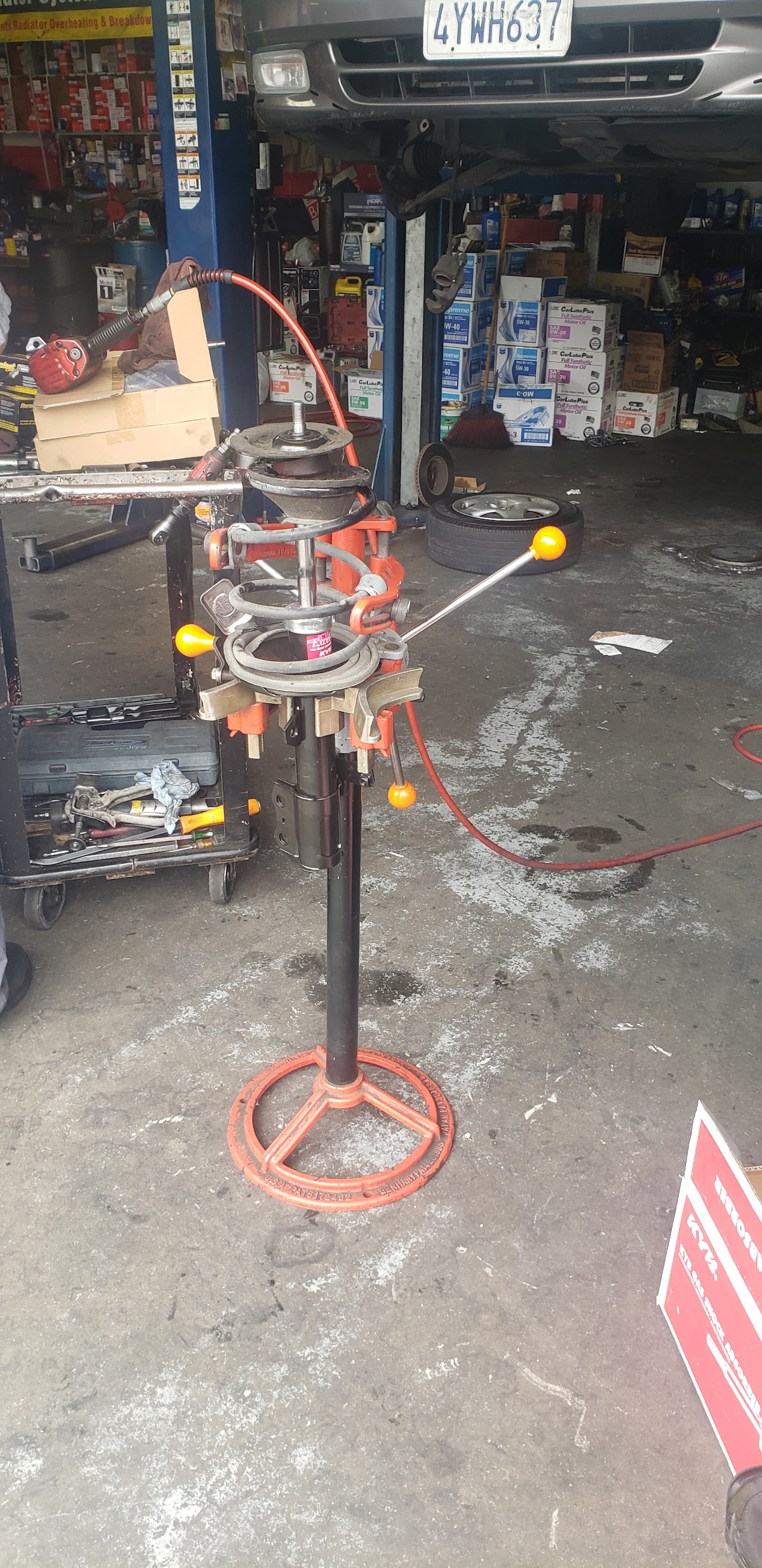 A technician working on a vehicle's suspension in the bay at O.R. General Auto Repair